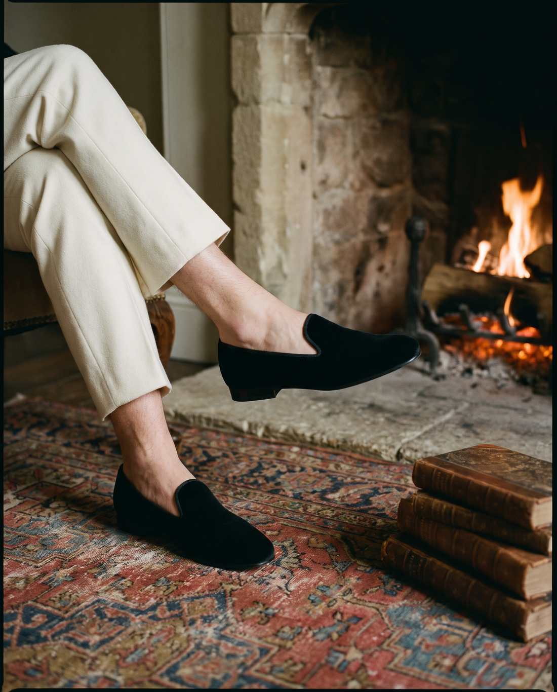 Black velvet slippers by a fireplace