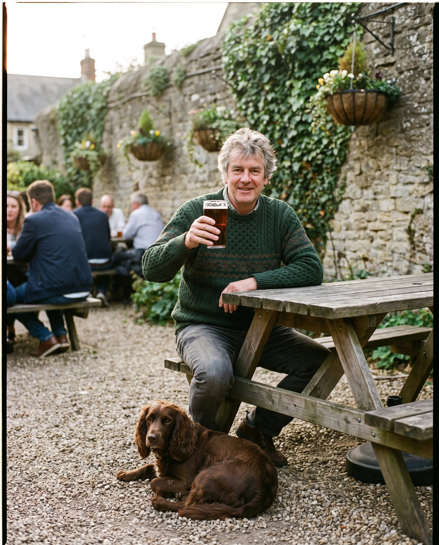Man in a green knit sweater in a pub garden